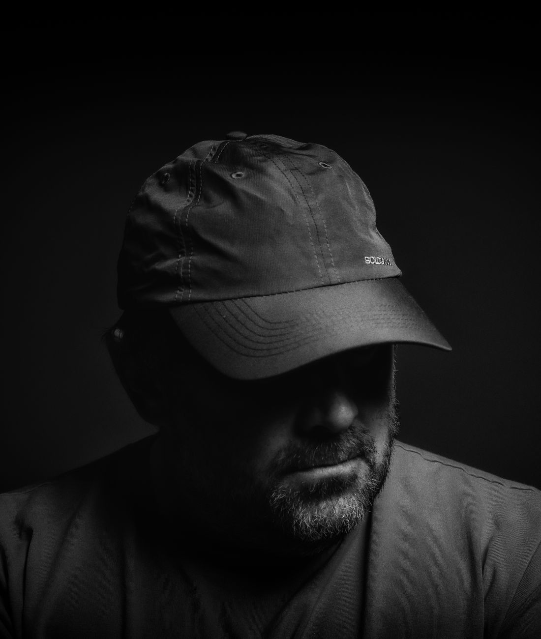 Hombre con gorra negra en penumbra